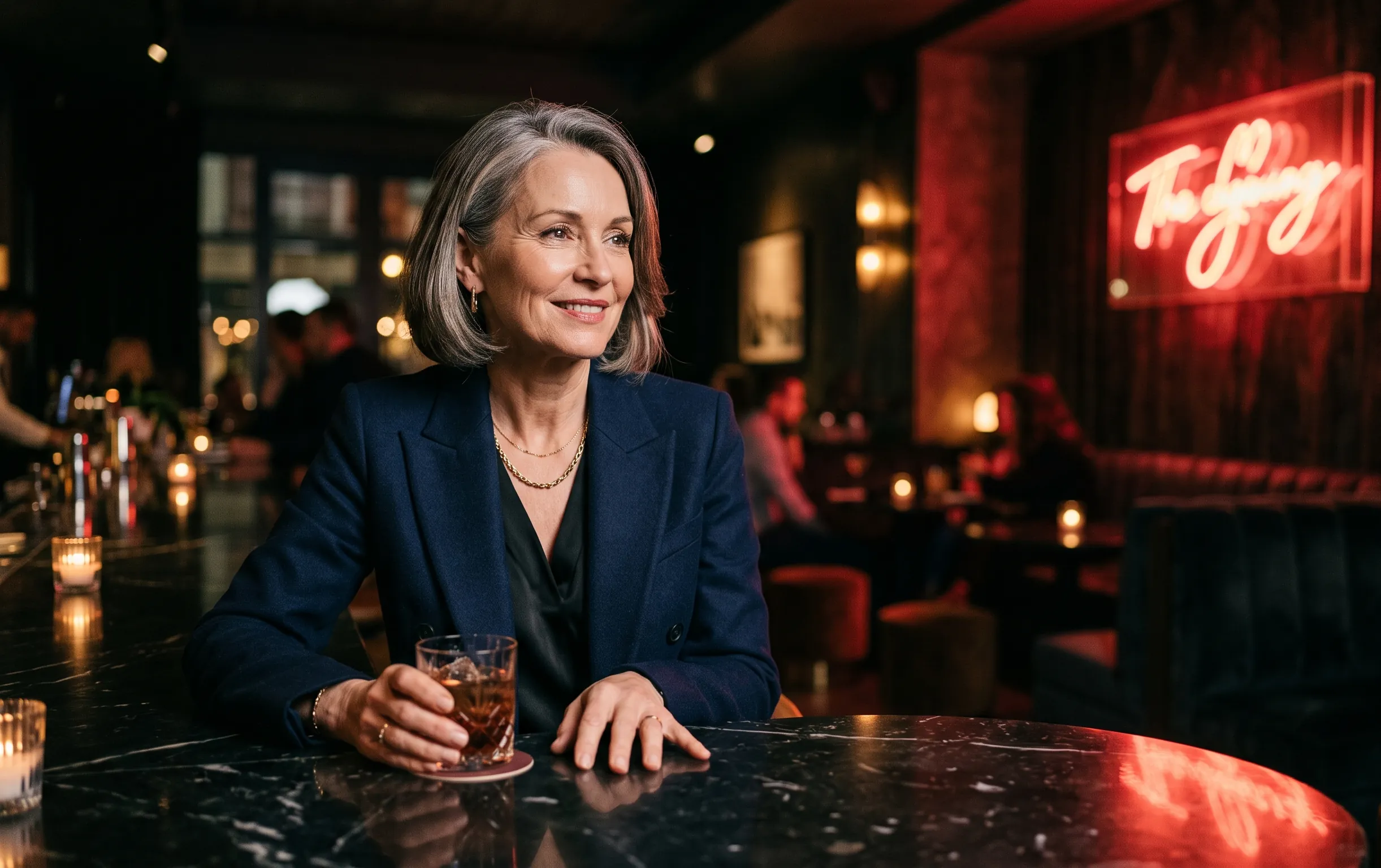Sugar mommy : la méthode pour fixer des règles claires 2 sugar mommy : Une femme élégante assise à une table dans un cadre feutré éclairé par une lumière néon rouge cerise